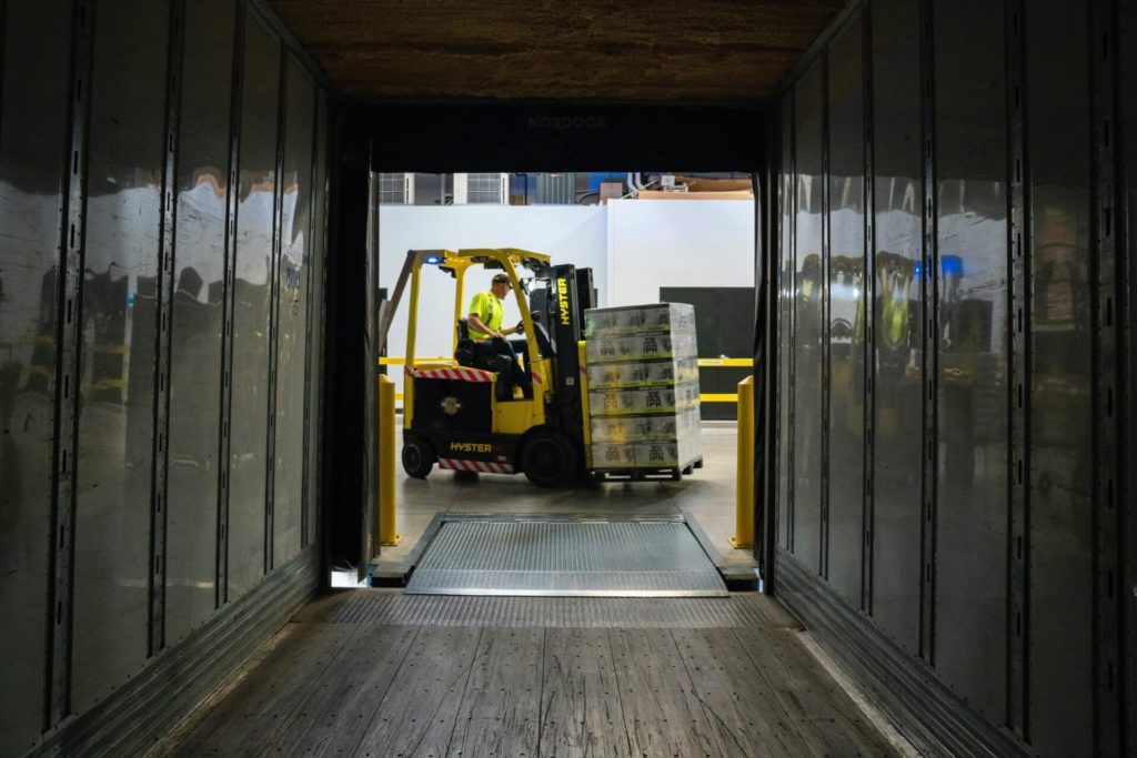 Forklift moving a pallet inside a truck