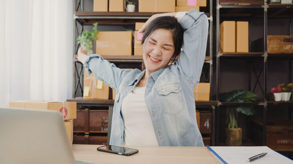 Asian entrepreneur business woman stretching her body after answ