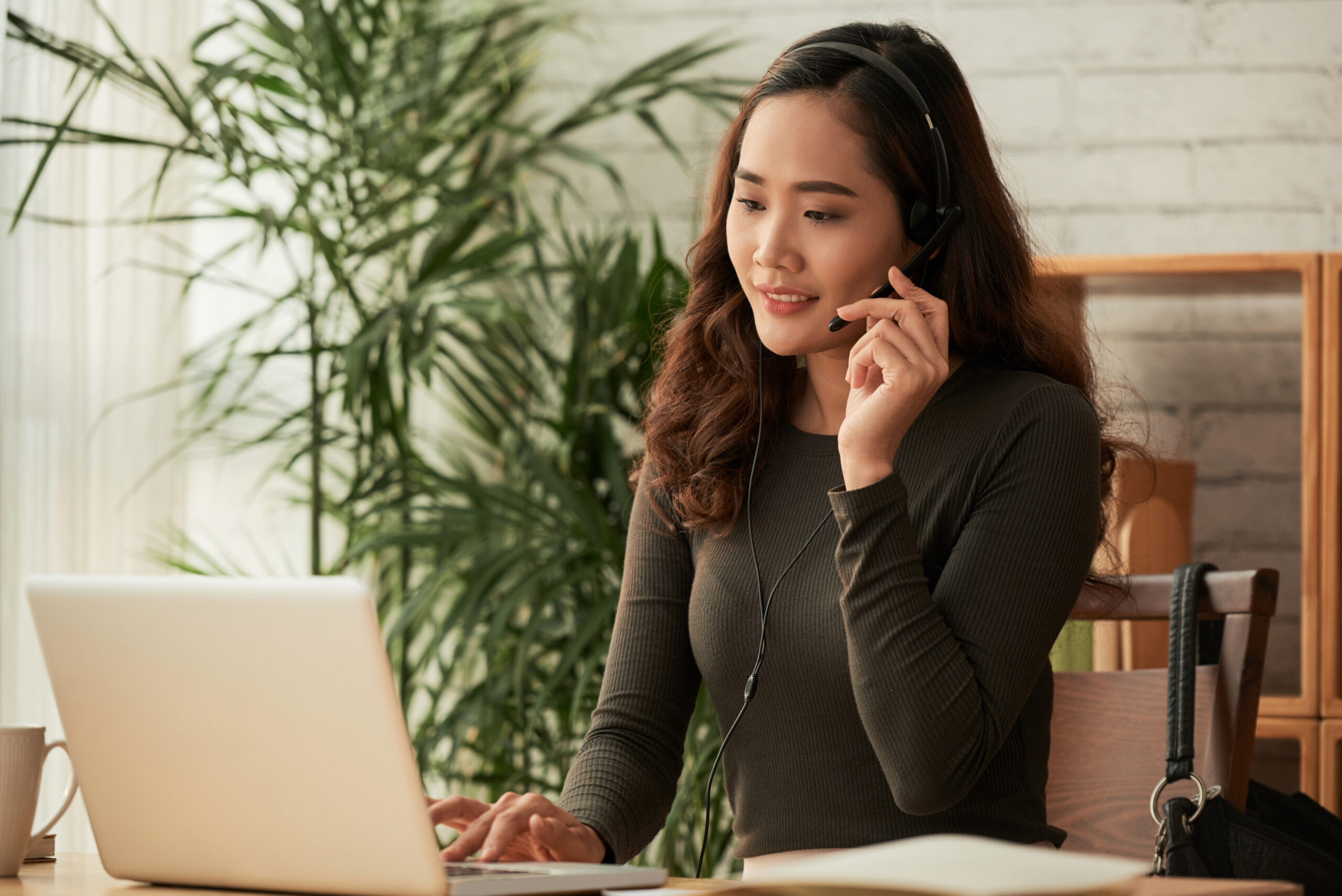 woman wearing a headset in front of a laptop