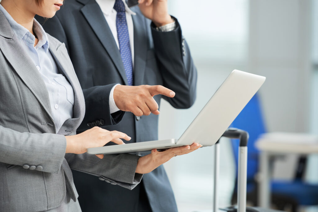 unrecognizable-man-woman-business-suits-looking-laptop-screen-together